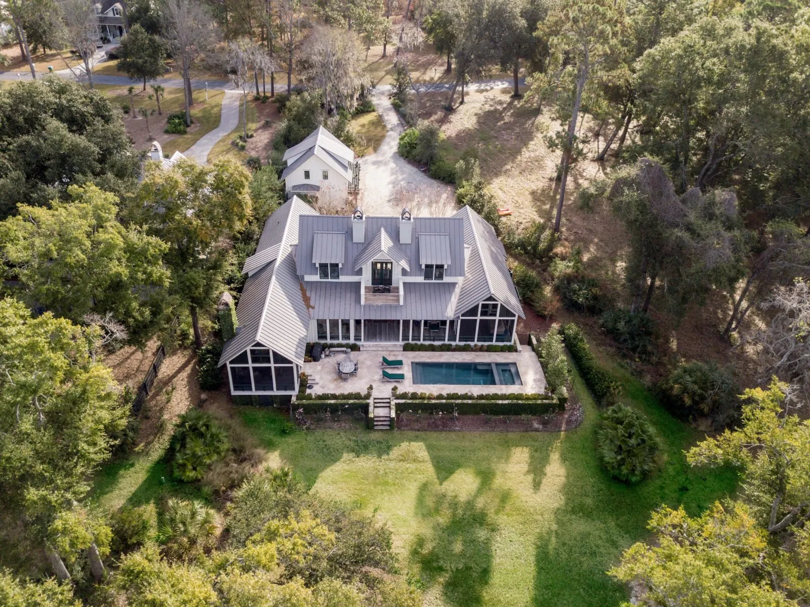 Aerial view of a large metal roof house with a pool