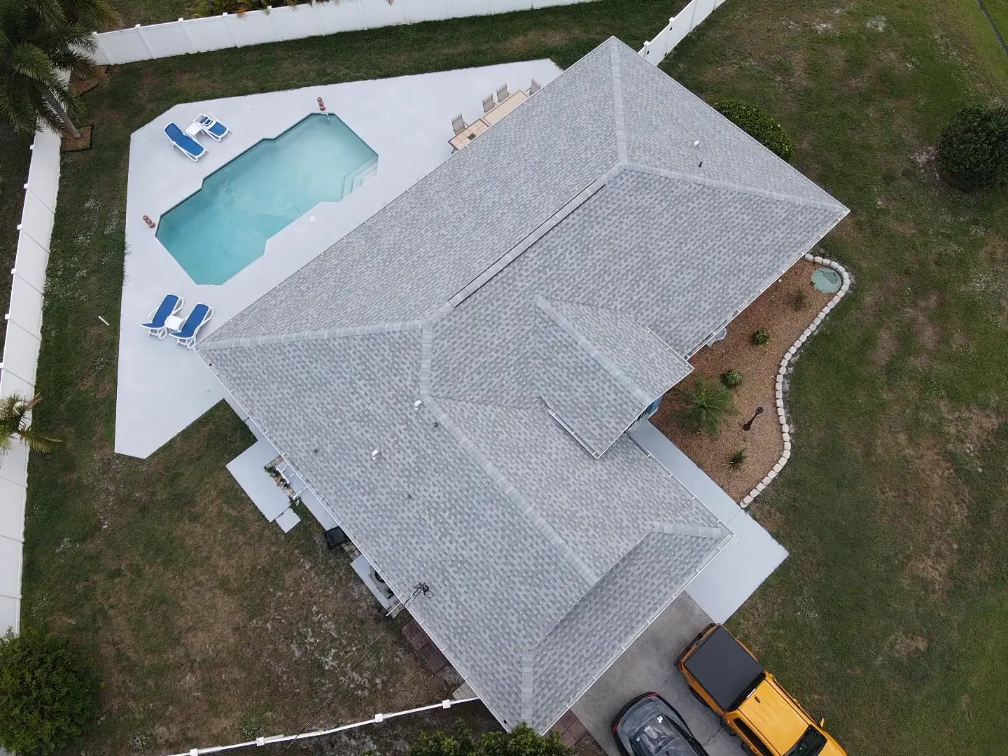 Aerial view of a Florida home with an asphalt shingle hip roof and pool