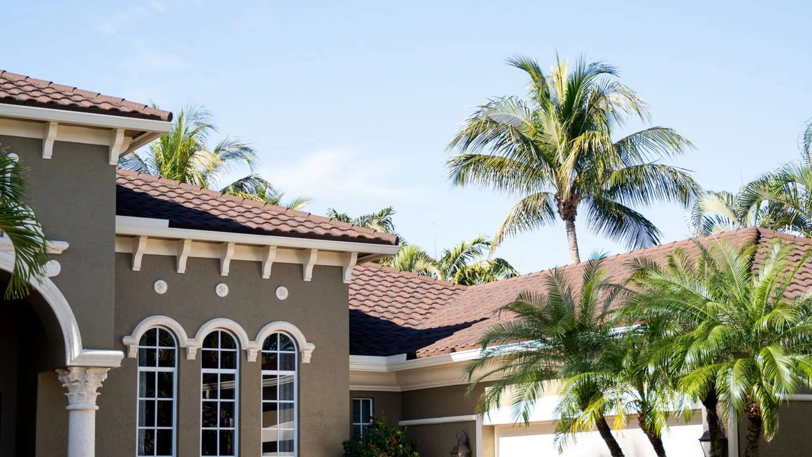 Florida home with a barrel tile roof and palms